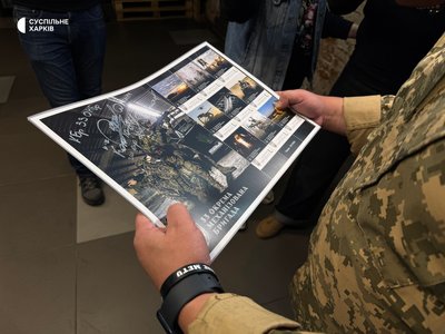 Військовий тримає у руках лист з марками, присвяченими 33-й ОМБр Військовий тримає у руках лист з марками, присвяченими 33-й ОМБр