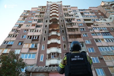 Рятувальник дивиться на пошкодження будинку Рятувальник дивиться на пошкодження будинку
