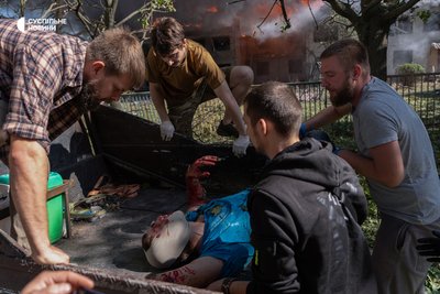 Чоловіки допомагають покласти пораненого у кузов військової автівки, щоб якнайшвидше довезти його у лікарню. Донеччина, 20 вересня 2026 року Чоловіки допомагають покласти пораненого у кузов військової автівки, щоб якнайшвидше довезти його у лікарню. Донеччина, 20 вересня 2026 року