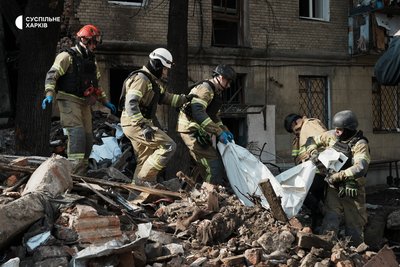 Рятувальники несуть тіло четвертої загиблої людини через російський удар по Холодногірському району Харкова Рятувальники несуть тіло четвертої загиблої людини через російський удар по Холодногірському району Харкова