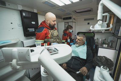 Стоматолог лікує зуби чоловіку Стоматолог лікує зуби чоловіку