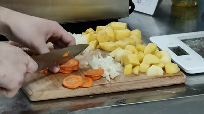 Кухар нарізає овочі Кухар нарізає овочі