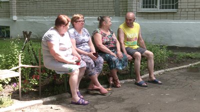 Переселенці сидять біля гуртожитку Переселенці сидять біля гуртожитку