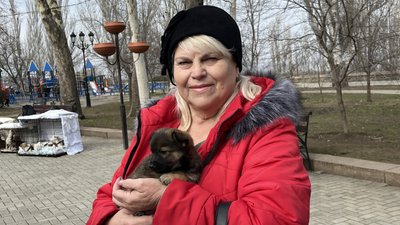 Місцева жителька Клавдія тримає у руках цуценя Місцева жителька Клавдія тримає у руках цуценя