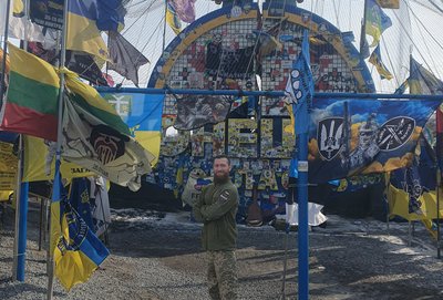 Військовослужбовець Артем із псевдо Саур поруч із стелою Донецької області Військовослужбовець Артем із псевдо Саур поруч із стелою Донецької області