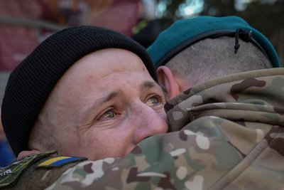 Українські військові, які повернулися з російського полону, обіймаються з рідними і побратимами