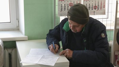 Чоловік заповнює заяву на виплату коштів Чоловік заповнює заяву на виплату коштів