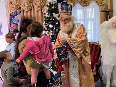 Святий Миколай дарує дитині подарунок Святий Миколай дарує дитині подарунок