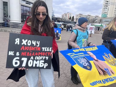 Учасниця акції тримає плакат і чекає безвісти зниклого рідного Учасниця акції тримає плакат і чекає безвісти зниклого рідного