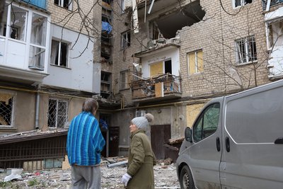 Жителі стоять біля зруйнованого багатоквартирного будинку у Херсоні 27 березня 2025 року Жителі стоять біля зруйнованого багатоквартирного будинку у Херсоні 27 березня 2025 року