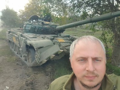 Дмитро Джумига на фоні танку у зоні бойових дій