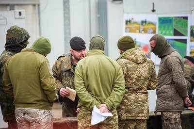 Українські військові слухають німецького інструктора на полігоні в Німеччині Українські військові слухають німецького інструктора на полігоні в Німеччині