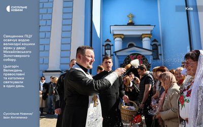 Священник ПЦУ освячує водою великодні кошики вірян у дворі Михайлівського Золотоверхого собору у Києві Священник ПЦУ освячує водою великодні кошики вірян у дворі Михайлівського Золотоверхого собору у Києві