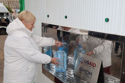 Жінка набирає воду з модульної установки у Вознесенську Жінка набирає воду з модульної установки у Вознесенську