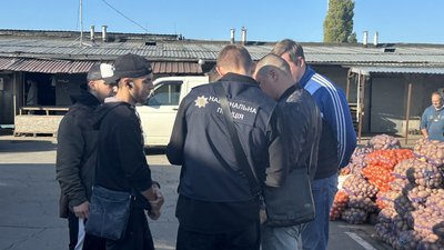 Співробітник міграційної поліції спілкується з людьми на ринку Співробітник міграційної поліції спілкується з людьми на ринку