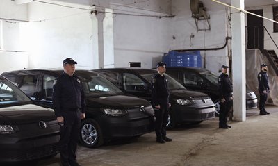 Поліцейські офіцери громад поруч із автівками Поліцейські офіцери громад поруч із автівками