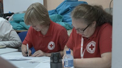 Представниці Товариства Червоного Хреста заповнюють документи у транзитному центрі, Харків, 15 липня 2026 року