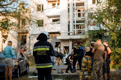 Мешканці та рятувальники біля пошкодженого будинку Мешканці та рятувальники біля пошкодженого будинку