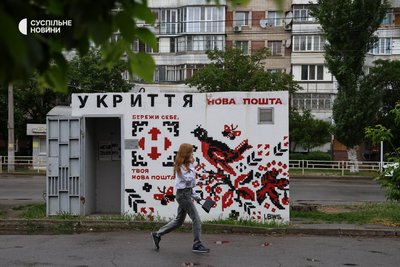 Дівчина проходить повз бетонне укриття в Таврійському мікрорайоні Херсона
