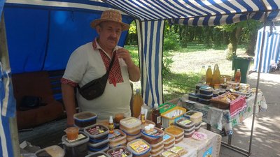 Пасічник продає продукти бджільництва на ярмарку Пасічник продає продукти бджільництва на ярмарку