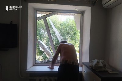 Мешканець квартири біля зруйнованого вікна в Одесі