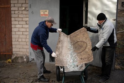 Чоловіки прибирають скло після ракетного удару по місту Дніпро 22 листопада 2024 року Чоловіки прибирають скло після ракетного удару по місту Дніпро 22 листопада 2024 року
