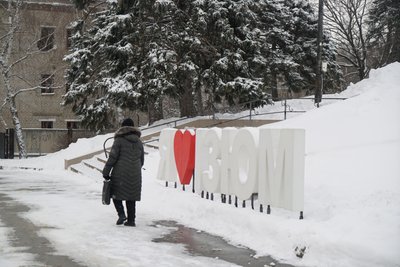 Жінка йде повз стеди "Я люблю Ізюм", 30 грудня 2025 року Жінка йде повз стеди "Я люблю Ізюм", 30 грудня 2025 року