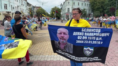 Учасниця акції із прапором, на якому знаходиться портрет рідного Учасниця акції із прапором, на якому знаходиться портрет рідного