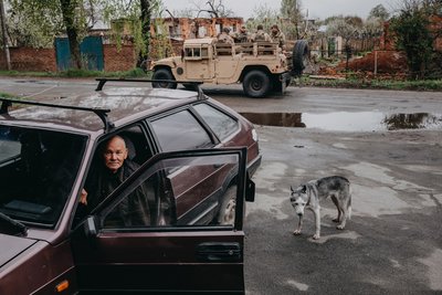 Місцевий житель у своїй машині та військові у Слатиному Дергачівської громади на Харківщині, 16 квітня 2024 року