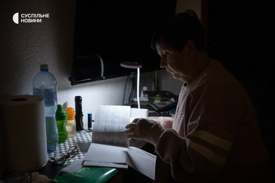 Ніна в квартирі у Києві під час відключення світла і опалення. Жінка вже на пенсії і більше року допомагає своєму сину Тарасу доглядати за онуком Богданом — дорослим чоловіком із важкою формою дитячого церебрального паралічу Ніна в квартирі у Києві під час відключення світла і опалення. Жінка вже на пенсії і більше року допомагає своєму сину Тарасу доглядати за онуком Богданом — дорослим чоловіком із важкою формою дитячого церебрального паралічу
