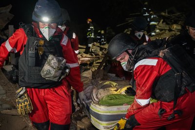 Медики несуть тіло загиблого чоловіка через удар КАБ по приватному сектору Харкова 29 жовтня 2024 року