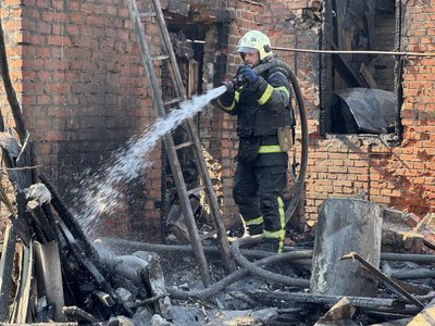 Рятувальник гасить пожежу на місці влучання російського безпілотника Рятувальник гасить пожежу на місці влучання російського безпілотника