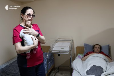 Медсестра тримає новонароджену дитину у сховищі однієї з лікарень міста, в яке пацієнти спускаються під час артилерійських обстрілів та повітряної тривоги