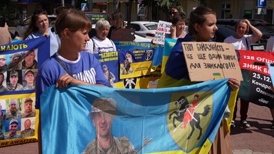 Учасники акції тримають плакати із закликами та прапори своїх бригад Учасники акції тримають плакати із закликами та прапори своїх бригад