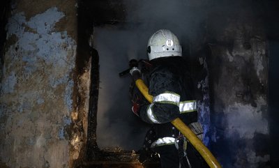 Рятувальник ДСНС гасить пожежу у будівлі
