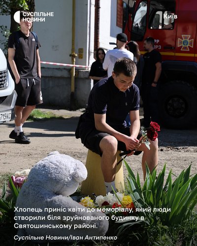 Хлопець приніс квіти до меморіалу, який люди створили біля зруйнованого ракетою будинку на Святошино у Києві Хлопець приніс квіти до меморіалу, який люди створили біля зруйнованого ракетою будинку на Святошино у Києві