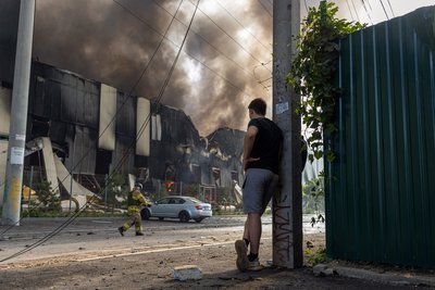 чоловік спостерігає, як рятувальники гасять пожежу в Одесі, 24 червня 2024 року чоловік спостерігає, як рятувальники гасять пожежу в Одесі, 24 червня 2024 року