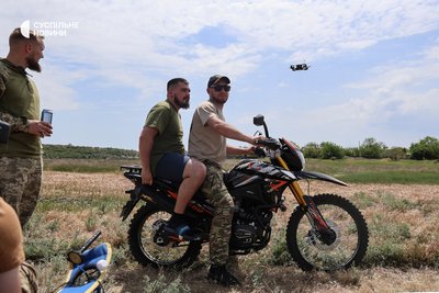 Командир підрозділу ударних БпЛА 505-го батальйону з позивним Демон за кермом мотоцикла. Херсонщина, травень 2025 року Командир підрозділу ударних БпЛА 505-го батальйону з позивним Демон за кермом мотоцикла. Херсонщина, травень 2025 року