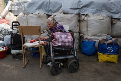 У пункті евакуації жителів Корабелу зустрічають спеціалісти з соціального відділу: консультують і допомагають оформити документи. Поряд з пунктом волонтери годують вивезених людей гарячими обідами. Херсон, 4 серпня 2025 року