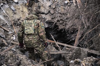 Слідчий заглядає у воронку, утворену після російського обстрілу у Златополі на Харківщині 10 грудня 2024 року Слідчий заглядає у воронку, утворену після російського обстрілу у Златополі на Харківщині 10 грудня 2024 року