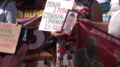 Учасники акція тримають плакати та фото своїх рідних Учасники акція тримають плакати та фото своїх рідних