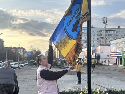 Місцева жителька Вікторія показує прапор Місцева жителька Вікторія показує прапор