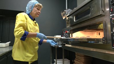 Працівниця піцерії у Ріпках на Чернігівщині готує піцу Працівниця піцерії у Ріпках на Чернігівщині готує піцу