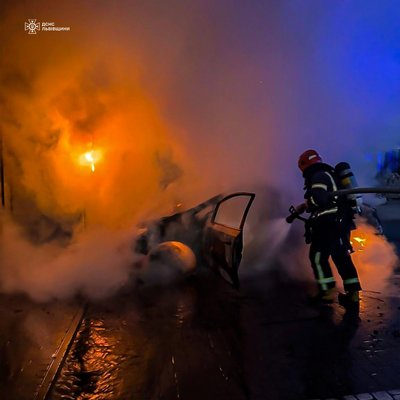 Рятувальник гасить пожежу авто Рятувальник гасить пожежу авто