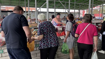 Люди купують овочі