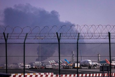 Літаки припарковані в міжнародному аеропорту Дубая. На задньому плані здіймається дим після того, як зранку дрон врізався в паливний бак. Це змусило тимчасово призупинити польоти. Об'єднані Арабські Емірати, 16 березня 2026 року Літаки припарковані в міжнародному аеропорту Дубая. На задньому плані здіймається дим після того, як зранку дрон врізався в паливний бак. Це змусило тимчасово призупинити польоти. Об'єднані Арабські Емірати, 16 березня 2026 року