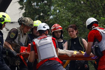 рятувальники та медики несуть поранену дитину, масований обстріл Києва, багатоповерхівка на Сирці, 8 липня 2024 року рятувальники та медики несуть поранену дитину, масований обстріл Києва, багатоповерхівка на Сирці, 8 липня 2024 року
