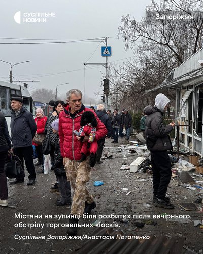 Містяни на зупинці транспорту біля розбитих після вечірнього обстрілу торговельних кіосків у Запоріжжя, 21 листопада 2025 року Містяни на зупинці транспорту біля розбитих після вечірнього обстрілу торговельних кіосків у Запоріжжя, 21 листопада 2025 року