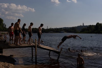 Хлопці стрибають у річку з невеликого пірса на пляжі у затоці Десенка у Лівобережному масиві у Києві, 13 липня 2024 року Хлопці стрибають у річку з невеликого пірса на пляжі у затоці Десенка у Лівобережному масиві у Києві, 13 липня 2024 року