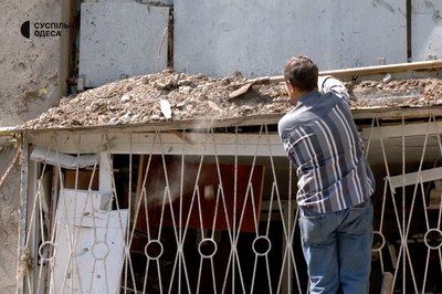 Мешканець будинку в Одесі прибирає будинок після атаки 23 липня